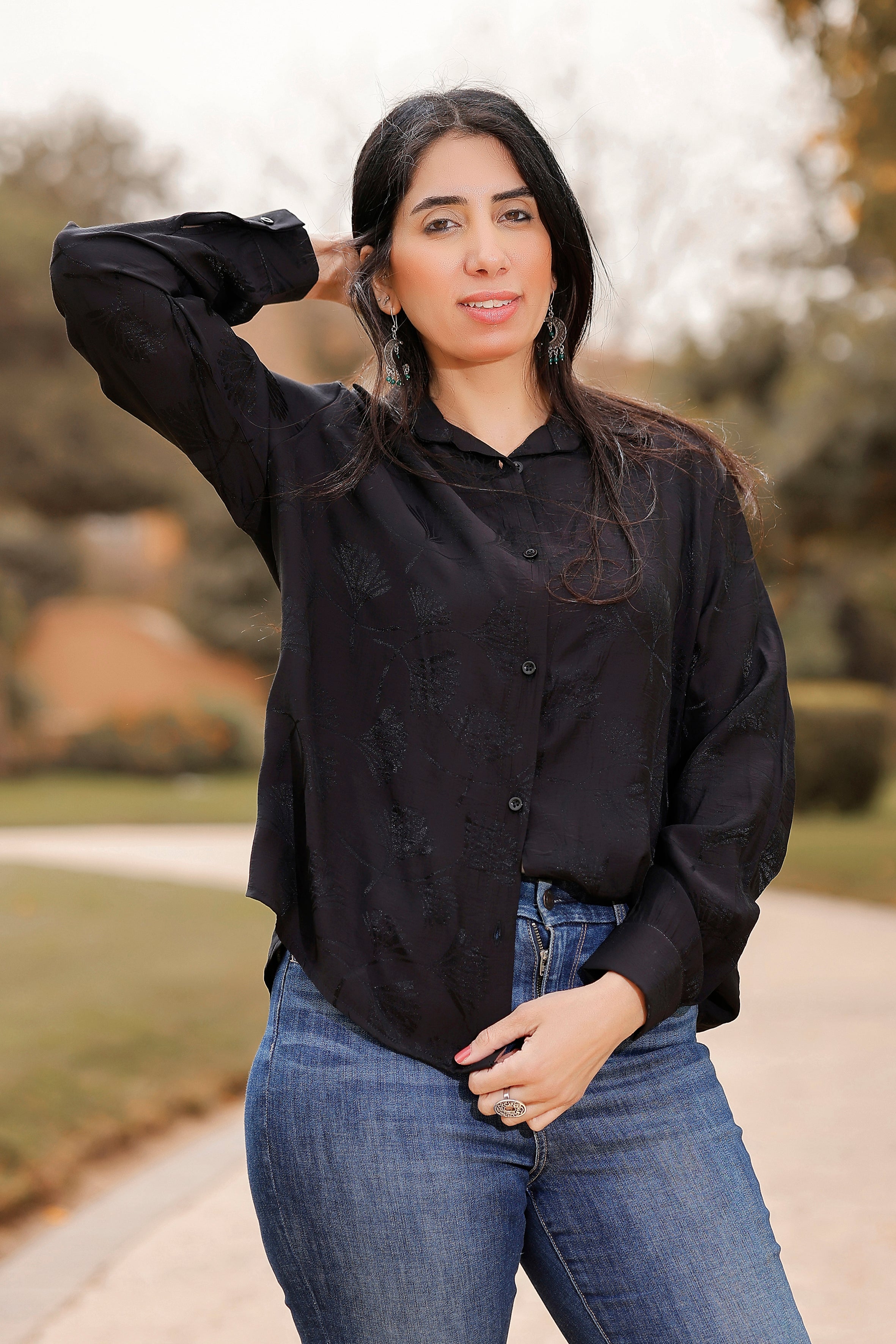 Woman wearing a black shirt and blue jeans outdoors