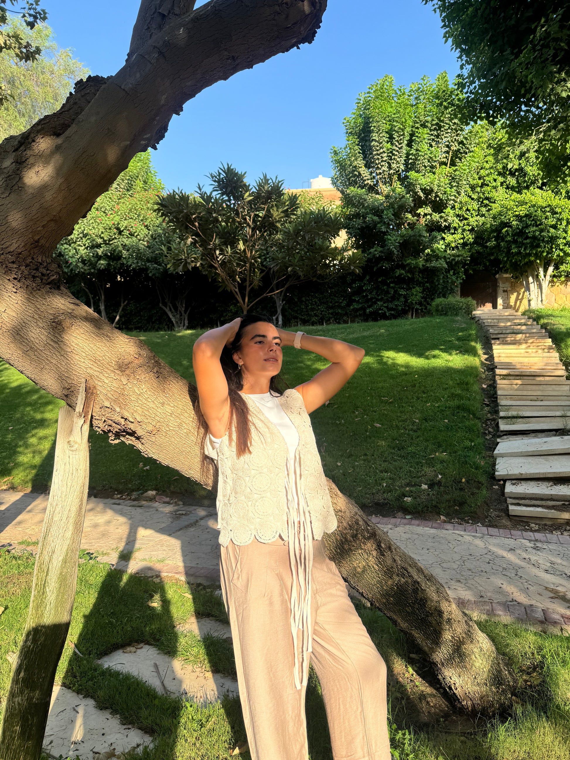 Woman standing under a large tree in a park-like setting