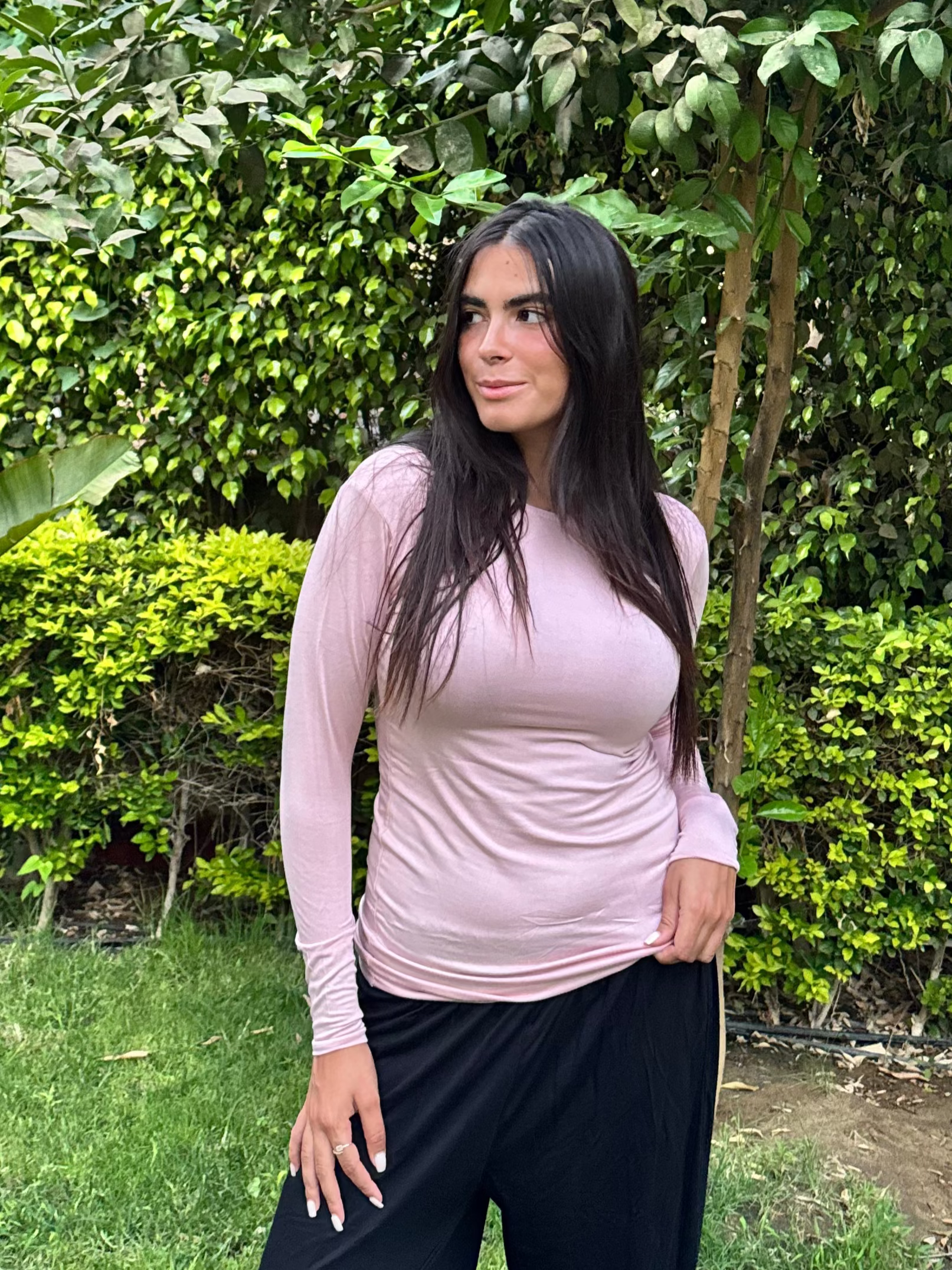 Woman standing in a garden with greenery around her